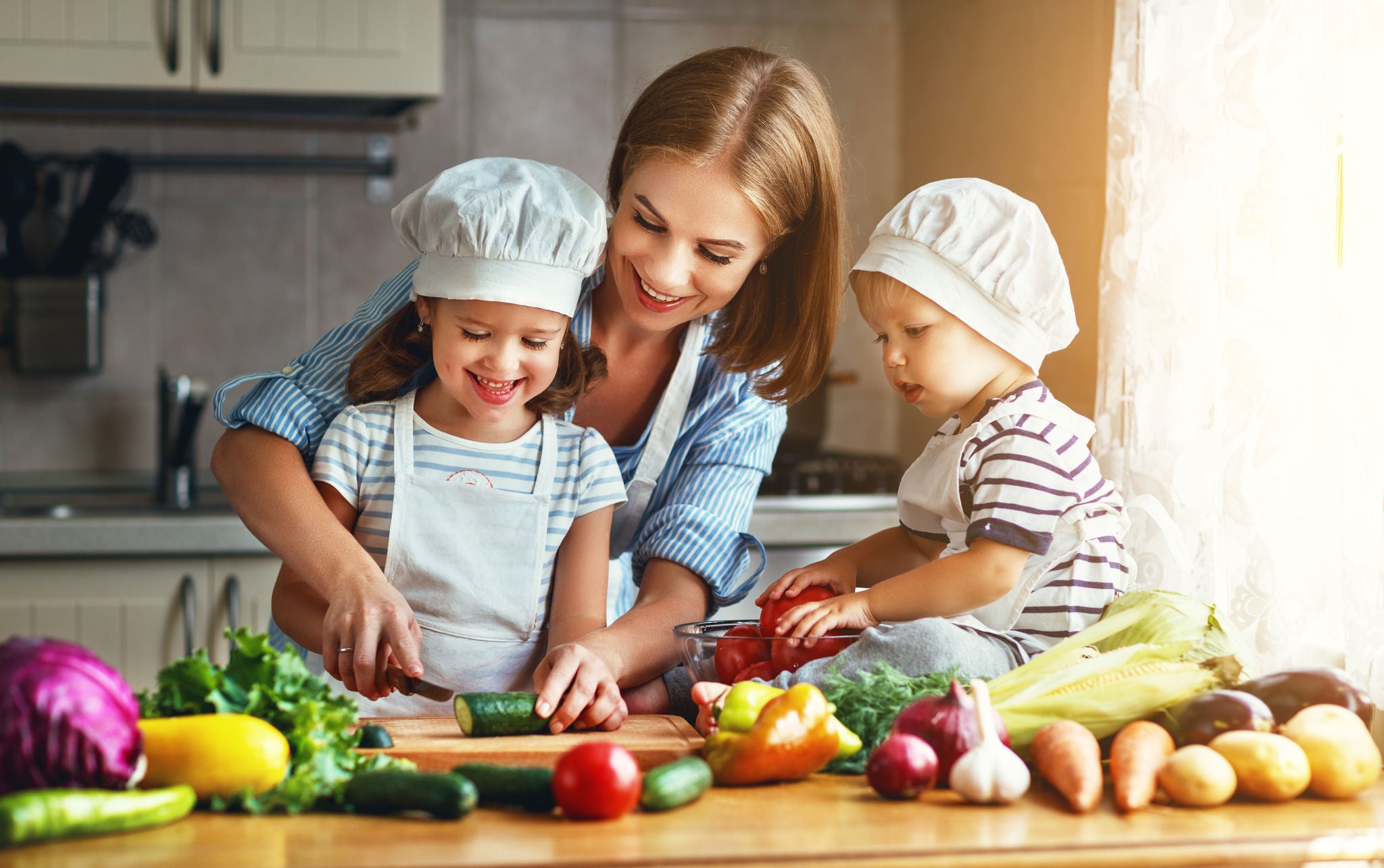 Happy-family-mother-and-children-prepares-vegetable-salad