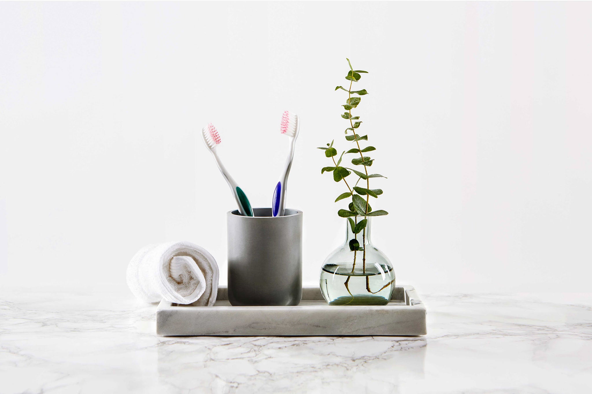 Sensivital toothbrush in glass on a table in bathroom