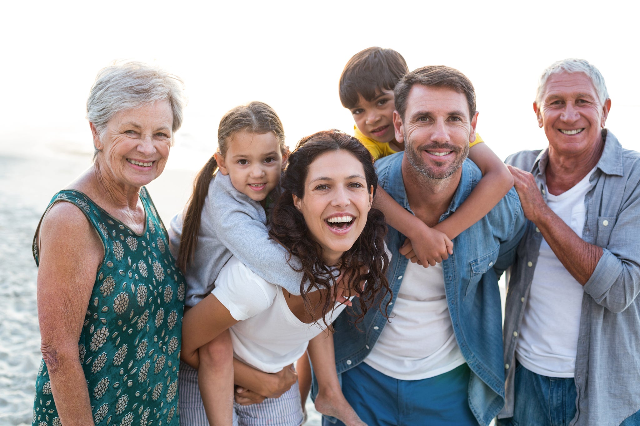 happy mulitgenerational family in the beach ocean mom dad woman man grandparents kids outdoor