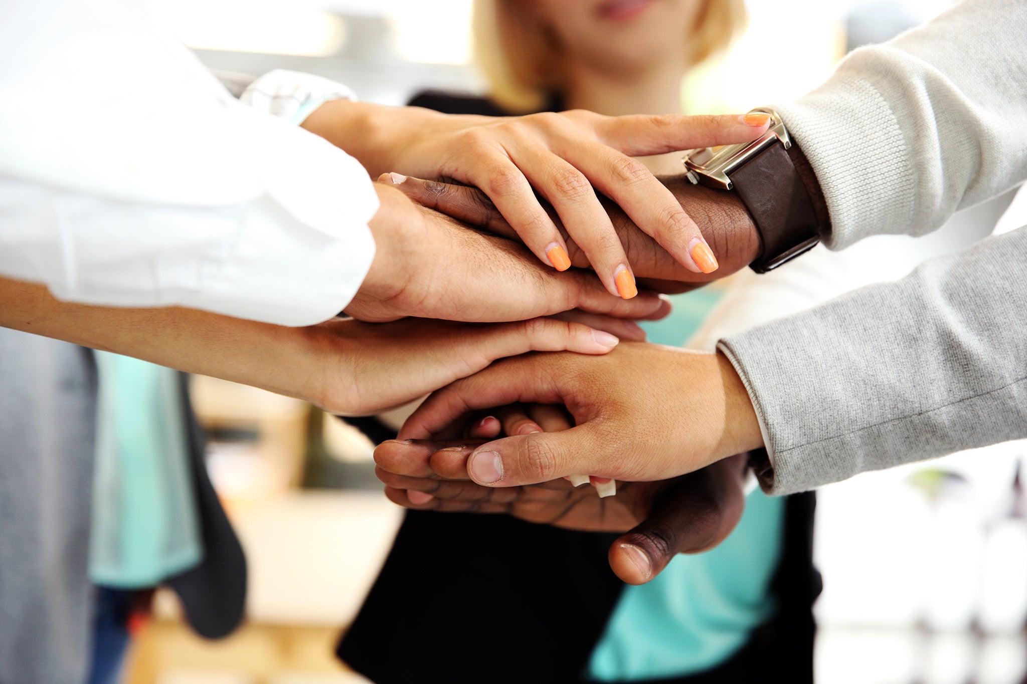 Business people joining hands indoor in office
