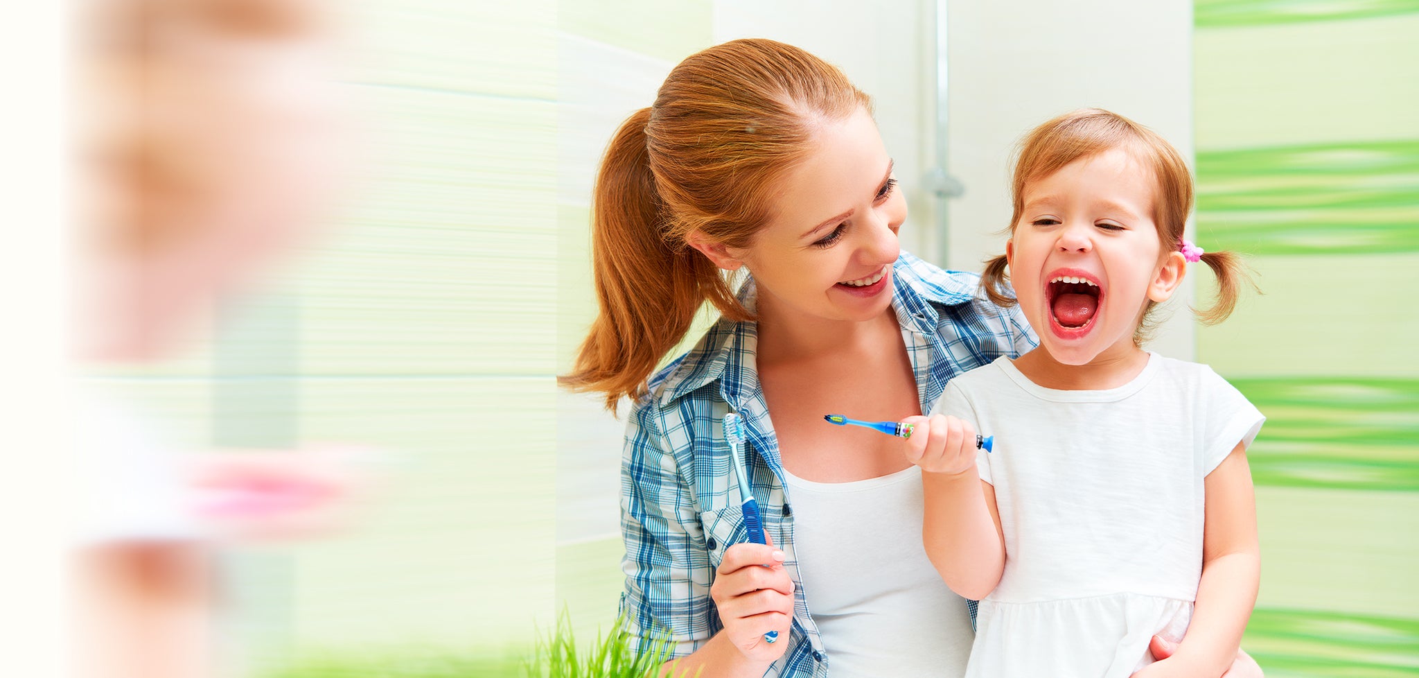 Mom and cute girl brushing their teeth in a bathroom kids Monster technique pro green