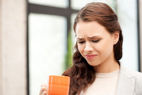 Woman-holding-cup-bitterness-in-mouth.jpg