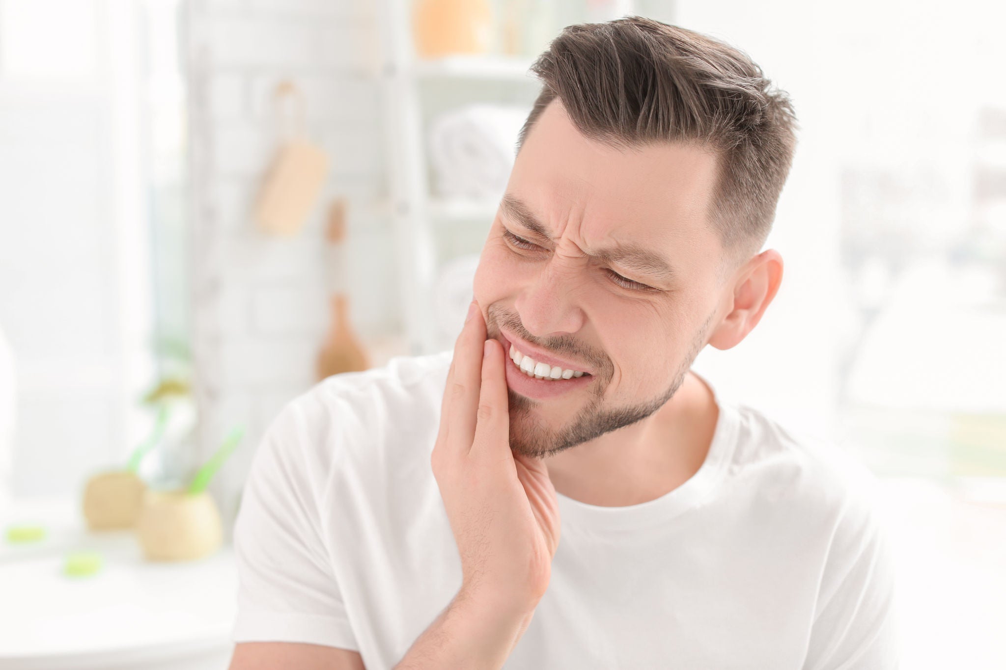 Young man suffering from toothache indoors