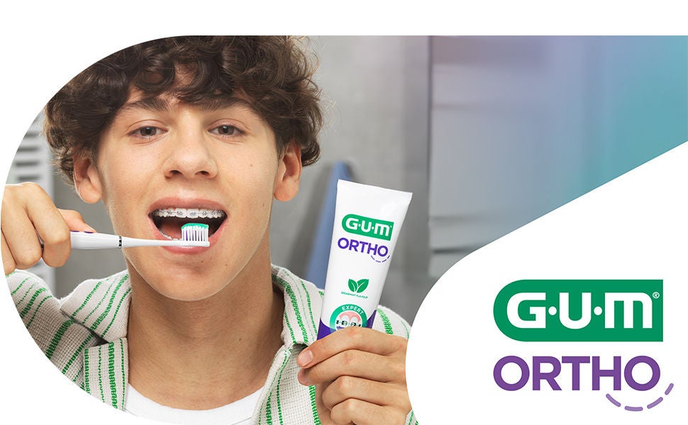 Smiling teen with braces is brushing his teeth with GUM SONIC ORTHO Toothbrush