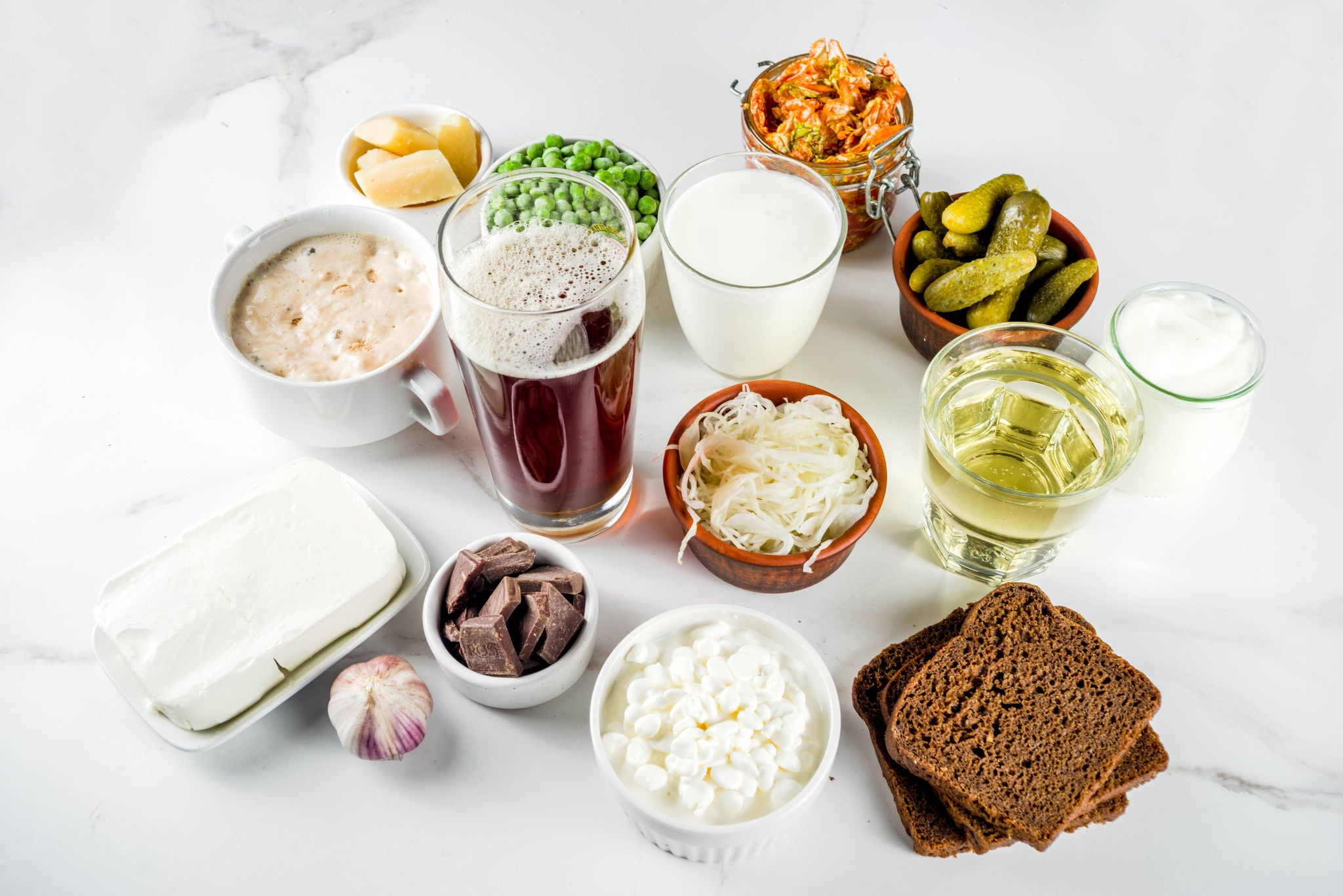 Super Healthy Probiotic Fermented Food Sources, drinks, ingredients, on white marble background copy space top view