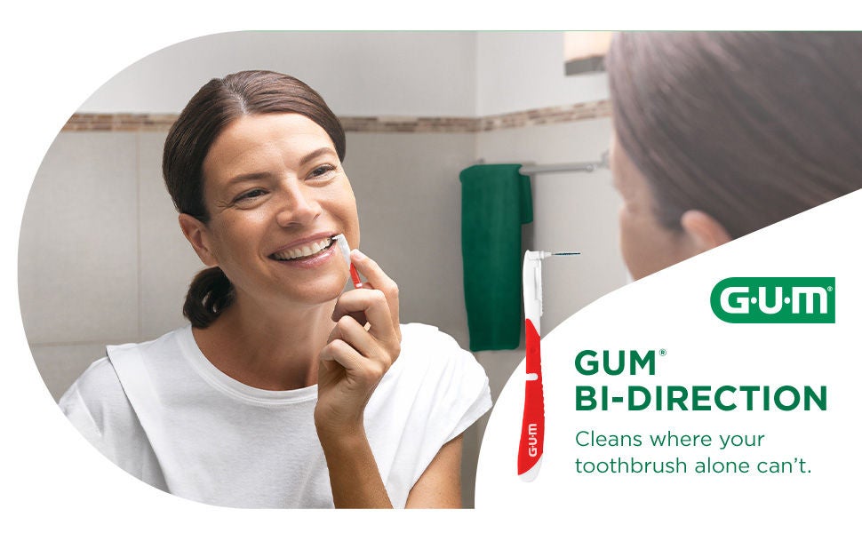 Smiling woman is cleaning between teeth with GUM BI-DIRECTION interdental brush