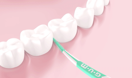 Palillo interdental GUM SOFT-PICKS ADVANCED limpiando entre los dientes