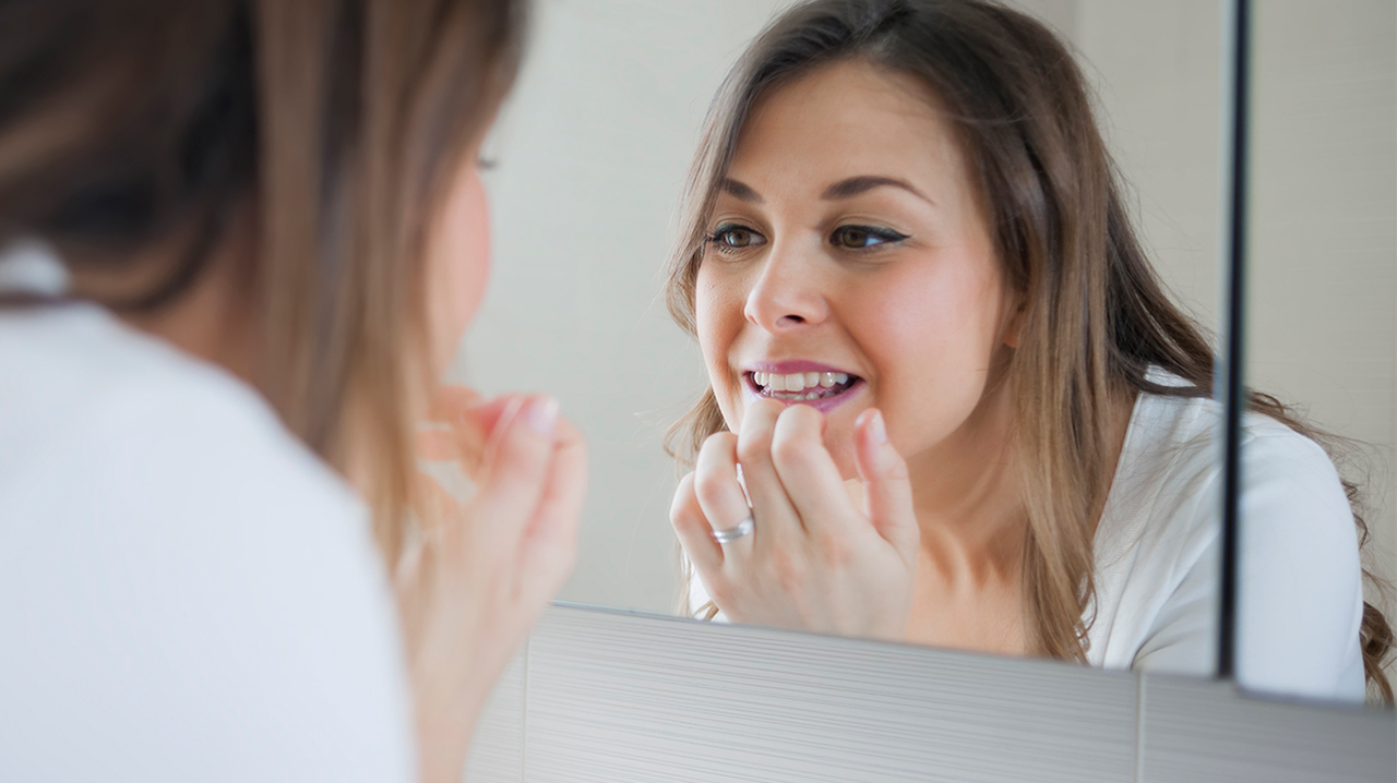 woman-checking-teeth-mirror.jpg