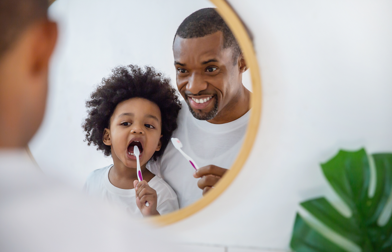 Père et fils se brossant des dents dans la salle de bain