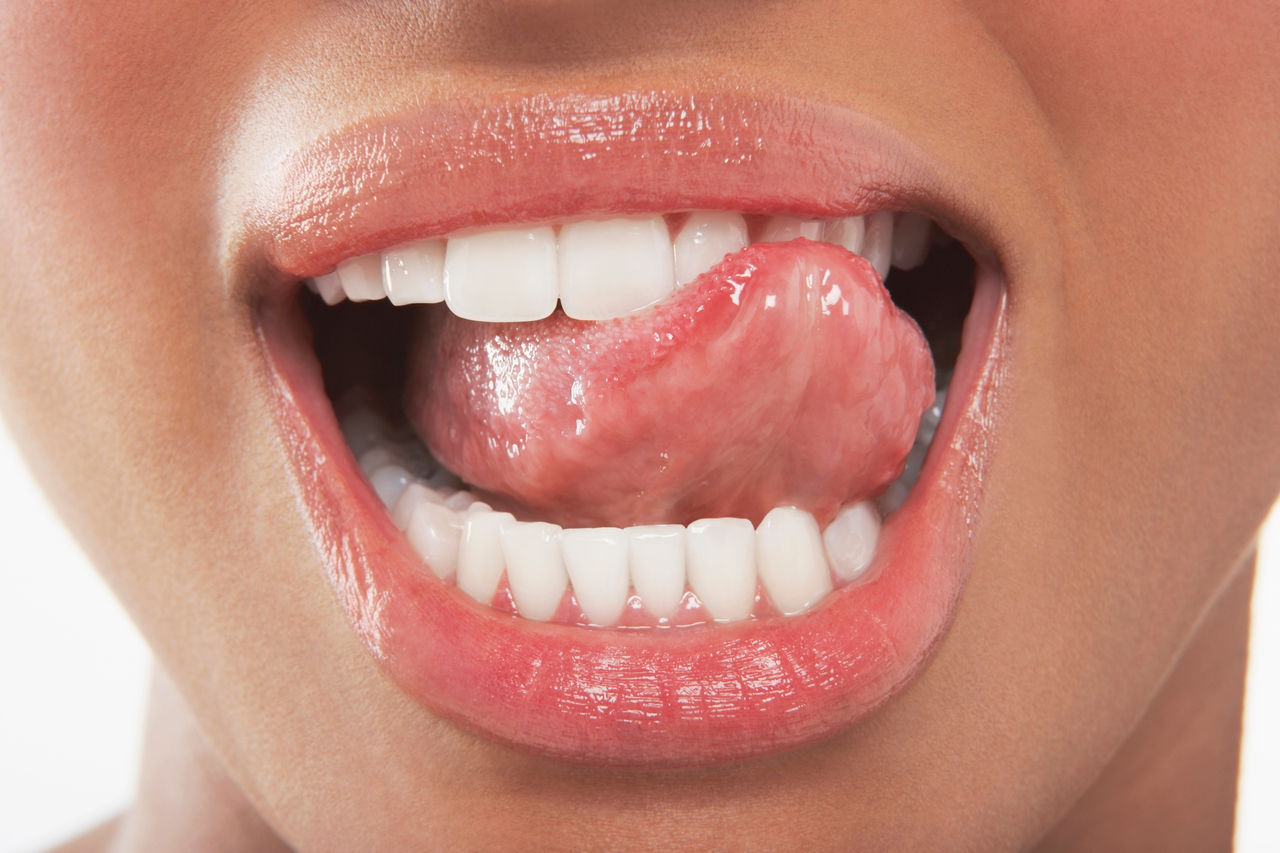Closeup of woman licking her teeth